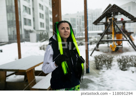 Woman Standing in Front of Playground in Snow 118091294