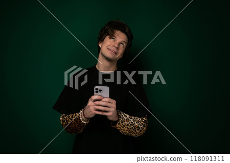 Man Holding Cell Phone Against Green Background Man Holding Cell Phone Against Green Background 118091311