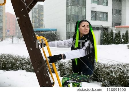 Woman Climbing Wooden Ladder in Snow Woman Climbing Wooden Ladder in Snow 118091600