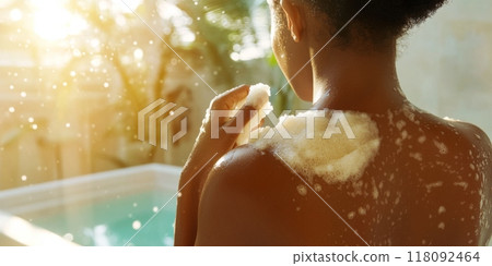 Woman taking bath in sunny bathroom, self-care concept 118092464