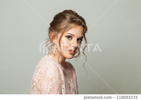 Perfect glam woman fashion model with makeup and updo hairstyle on gray studio background Perfect glam woman fashion model with makeup and updo hairstyle on gray studio background 118093235