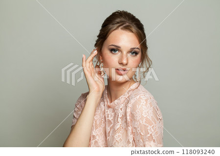 Attractive adorable woman wearing pink lace blouse. Model with make-up and updo hair Attractive adorable woman wearing pink lace blouse. Model with make-up and updo hair 118093240
