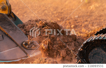 Metal bucket of backhoe digging soil. Excavator working at construction site. Earth moving machine. Excavation vehicle. Heavy machinery in action. Construction machinery and earth-moving equipment. 118093531