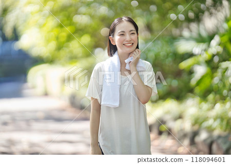 穿著運動服行走的微笑的年輕女子 118094601