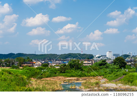 A river under the summer sky and a residential area rich in nature 118096255