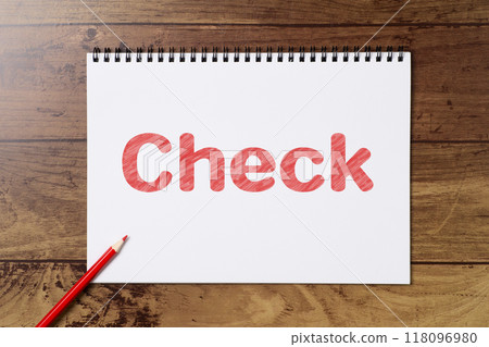 Colored pencils and a coloring book image of the word "Check" 118096980