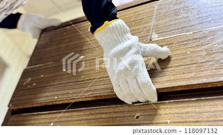 一隻戴著工作手套的手拿著一個舊抽屜櫃 一隻戴著工作手套的手拿著一個舊抽屜櫃 118097132