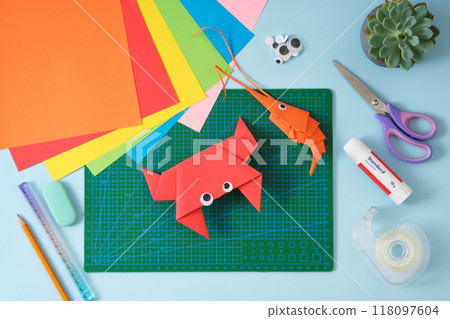 Top view of paper cutting tools, scissors, cutter, and crab and shrimp paper craft toys. DIY project concept for kids. Flat lay 118097604