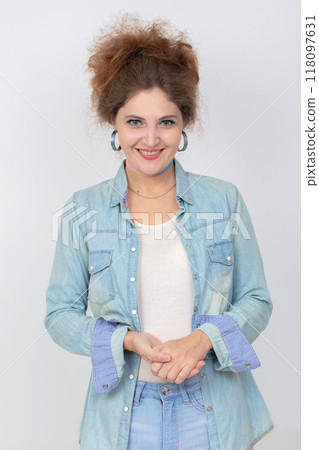 Portrait of a happy young woman in a denim shirt looking at the camera and smiling. Portrait of a happy young woman in a denim shirt looking at the camera and smiling. 118097631