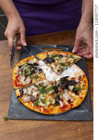 Cut the cheap pizza into pieces. Cut the cheap pizza into pieces. 118097717