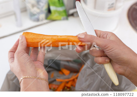 Hands hold peeled carrots and a knife. Hands hold peeled carrots and a knife. 118097722