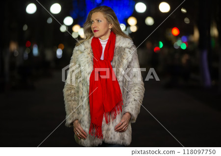 Portrait of a beautiful middle-aged woman in a beautiful evening city. She is looking for a man. Portrait of a beautiful middle-aged woman in a beautiful evening city. She is looking for a man. 118097750