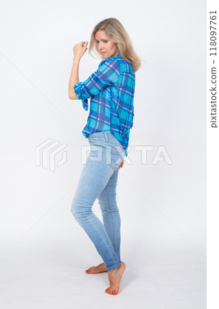 A full-length middle-aged woman in jeans and a shirt. A full-length middle-aged woman in jeans and a shirt. 118097761