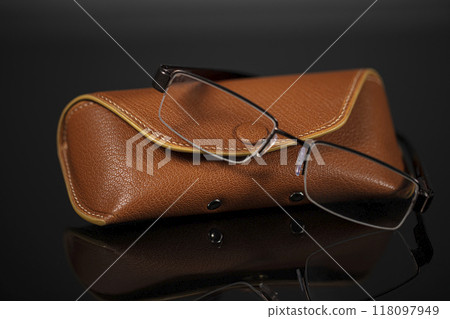 Glasses with leather case on a black background. 118097949