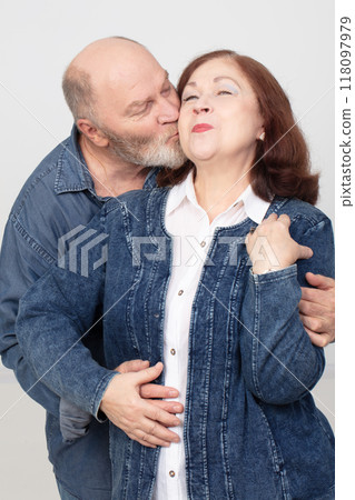 Portrait of an elderly couple in love, an affectionate adult husband kisses his beautiful wife. 118097979