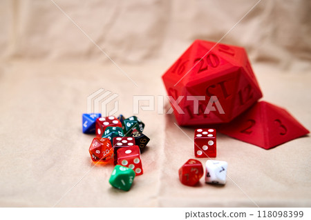 Diverse collection of colored dice on a cardboard surface 118098399