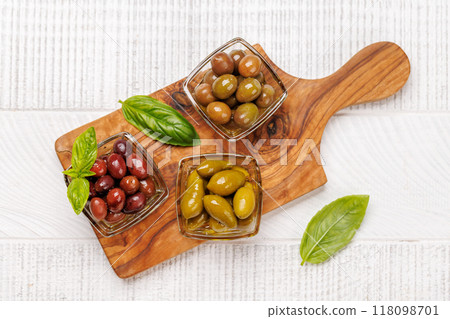 An assortment of various olives presented in a bowl, showcasing different colors, textures, and flavors 118098701