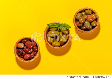 An assortment of various olives presented in a bowl, showcasing different colors, textures, and flavors 118098716