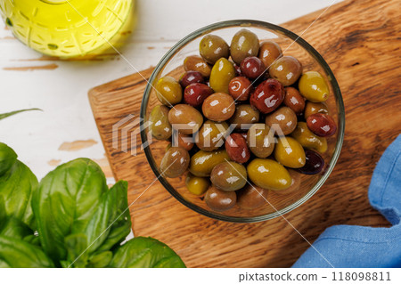 An assortment of various olives presented in a bowl, showcasing different colors, textures, and flavors 118098811