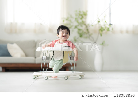 10-month-old boy walking with a walker 10-month-old boy walking with a walker 118098856