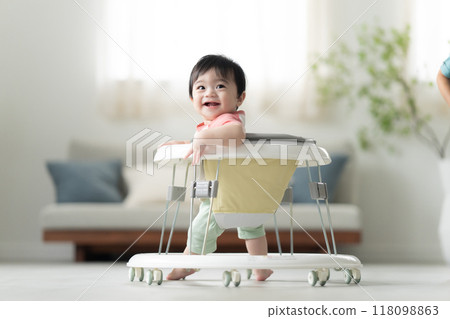 10-month-old boy walking with a walker 118098863