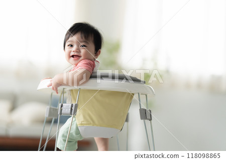 10-month-old boy walking with a walker 118098865