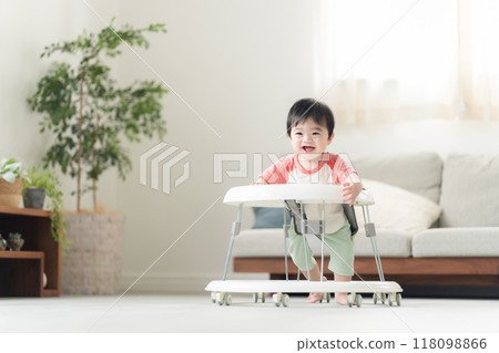 10-month-old boy walking with a walker 10-month-old boy walking with a walker 118098866