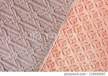 Knitted brown and red background. Large knitted fabric with a pattern. Close-up of a knitted blanket 118098897