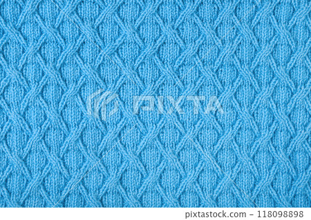 Knitted blue background. Large knitted fabric with a pattern. Close-up of a knitted blanket Knitted blue background. Large knitted fabric with a pattern. Close-up of a knitted blanket 118098898