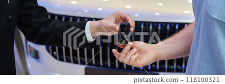 Cropped shot of unrecognizable auto dealers passing smart key to new owner at car dealership center Cropped shot of unrecognizable auto dealers passing smart key to new owner at car dealership center 118100321