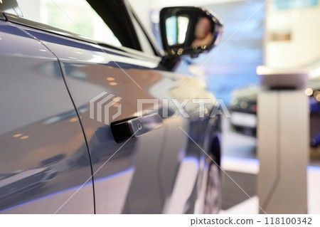 Close up on shiny gray coat of car with flush door handles popping out from vehicles surface. New automobile displayed in showroom, copy space 118100342