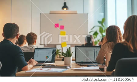 Business team in a meeting with laptops, focusing on strategy and planning. Collaborative corporate culture with teamwork. 118100564