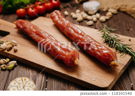 Delicious smoked sausages on a wooden board, perfect for culinary presentations and food photography 118101540