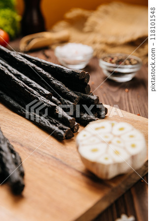 Rustic black meat sticks with herbs and spices on board, perfect for gourmet and food photography Rustic black meat sticks with herbs and spices on board, perfect for gourmet and food photography 118101548