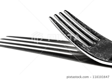 Closeup of a fork horizontally on a white surface, with a harsh shadow 118101647