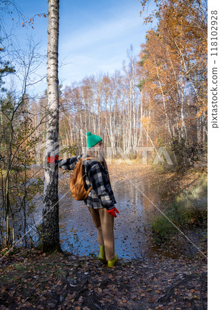 Middle aged woman walking in natural autumn park near frozen pond. Solo traveling, nature lover. Middle aged woman walking in natural autumn park near frozen pond. Solo traveling, nature lover. 118102928