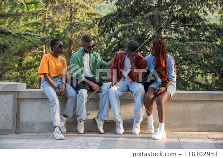 Sympathetic sad friends teens gently attentively support suffering fellow hugging patting on back Sympathetic sad friends teens gently attentively support suffering fellow hugging patting on back 118102931