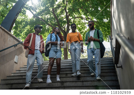 Interested black four girls and guys students down to stairs to underpass chatting going in college. 118102939