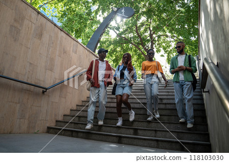 Peaceful carefree walk of African American stylish students friends on street in sunny weather. Peaceful carefree walk of African American stylish students friends on street in sunny weather. 118103030
