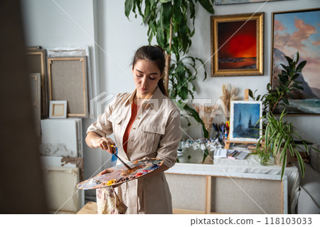 Focused artist woman working on painting, girl painter concentrated on work make create oil artwork 118103033