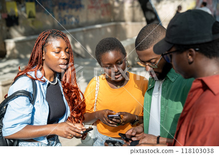Interested serious group of black students communicate by sharing study information uses smartphones 118103038