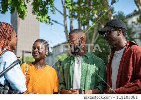 Happy African American friends classmates spending pleasant time together outdoors in sunny weather. Happy African American friends classmates spending pleasant time together outdoors in sunny weather. 118103061