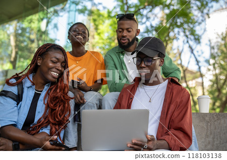 Happy cheerful group of students friends studying together with laptop outdoors with laugh and smile Happy cheerful group of students friends studying together with laptop outdoors with laugh and smile 118103138