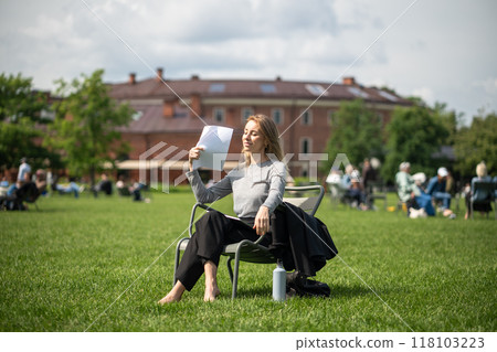 Relaxed pleased woman resting in nature park on lawn outdoors outside at fresh open air, space. 118103223