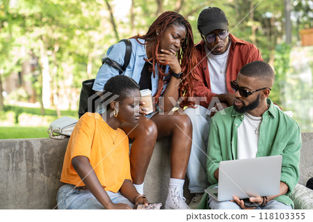 Focused interested group of black students pensive looks at laptop prepare to test sits near college Focused interested group of black students pensive looks at laptop prepare to test sits near college 118103355