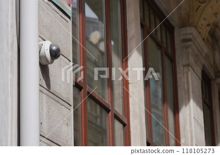 A surveillance camera has been installed on the exterior of the building featuring reflections A surveillance camera has been installed on the exterior of the building featuring reflections 118105273