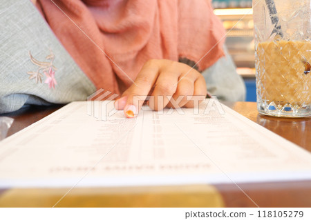 women hand reading a food menu at cafe. women hand reading a food menu at cafe. 118105279