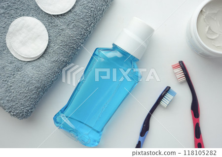 mouthwash liquid in a container and toothbrush on white background  118105282