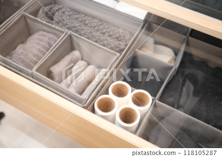 A wellorganized storage drawer featuring soft and fluffy textile accessories for neatness 118105287