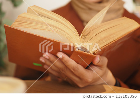 A person is reading a book in a cozy and inviting setting that radiates warmth and comfort A person is reading a book in a cozy and inviting setting that radiates warmth and comfort 118105350